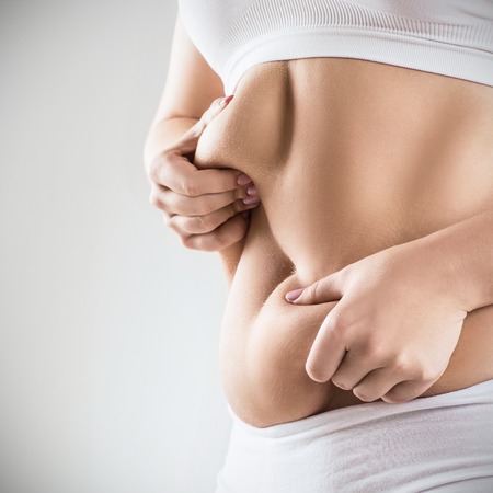 Woman in white underwear holds belly fat.の写真素材