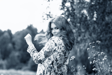 Young redhead woman posing in summer park.の写真素材