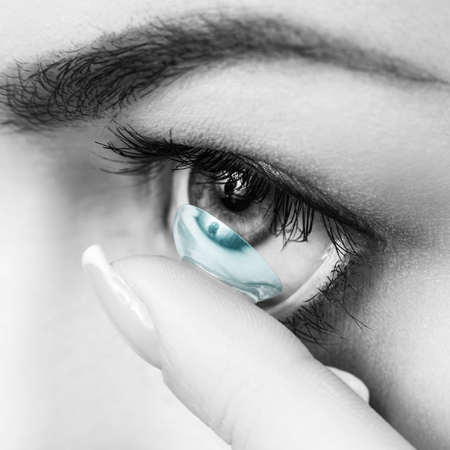 Close-up shot of young woman wearing contact lens.の写真素材