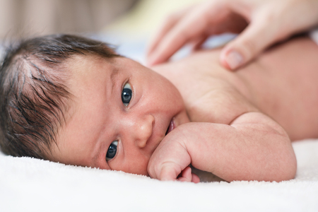 Cute newborn baby looking at the camera.の写真素材
