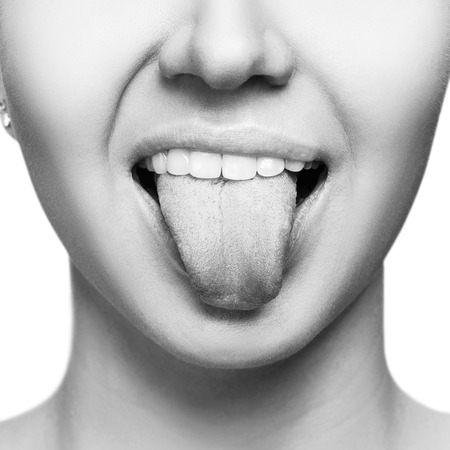 Close-up portrait of woman shows tongue grimace.の写真素材