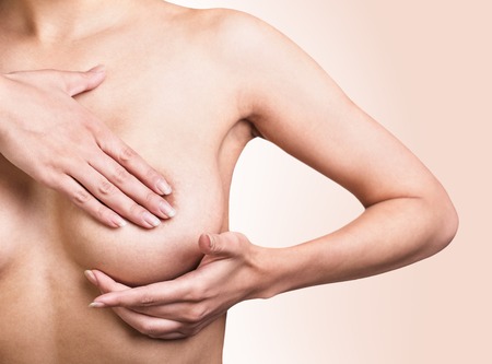 Woman examining her breast for signs of breast cancer.の写真素材