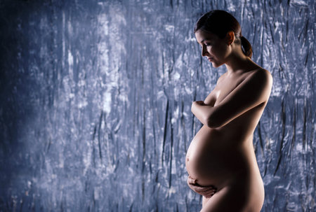Naked pregnant woman with a huge beautiful belly.の写真素材