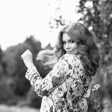 Young redhead woman posing in summer park.の写真素材