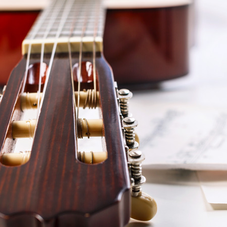 Closeup shot of guitar fingerboard and sheet with notes.の写真素材