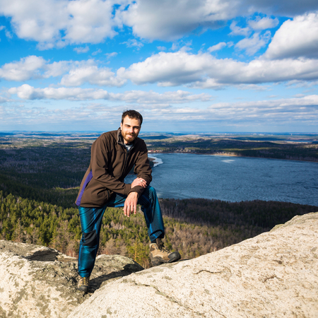 Young man standing on the top of the rock.の写真素材