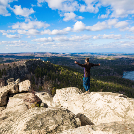 Young man standing on the top of the rock.の写真素材