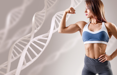 Athletic fitness woman standing among DNA chains.の写真素材