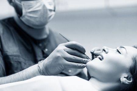 Dentist check-up teeth to young woman patient in clinic.の写真素材
