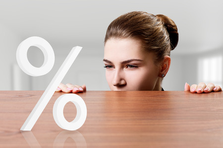 Business woman looking on perscent sign under the edge of table.の写真素材