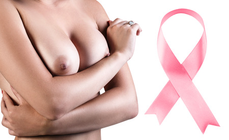 Young woman touching her breast near big pink ribbon.の写真素材