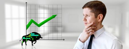 Thoughtful businessman looks on silhouette bull financial icon.の写真素材