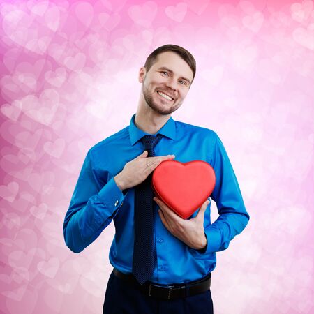 Elegant man with valentines gift box in the shape of heart.の写真素材