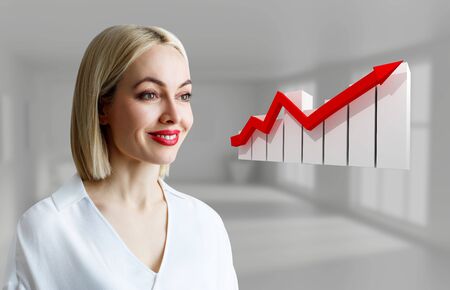 Business woman looks on increase schedule woth growth arrow.の写真素材