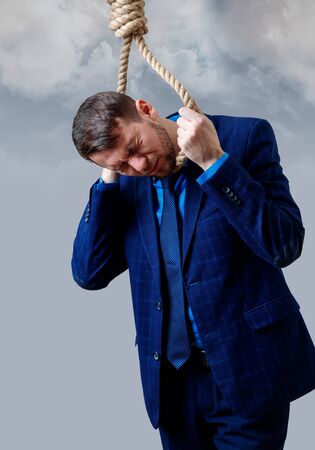 Depressed businessman wearing rope loop committing suicide.の写真素材