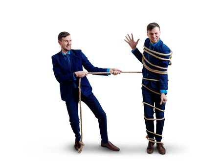 Angry businessman pulls tied himself with a rope.の写真素材