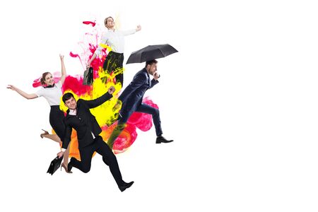 Happy office workers jumping in suits among colorful inks exlosion.の写真素材