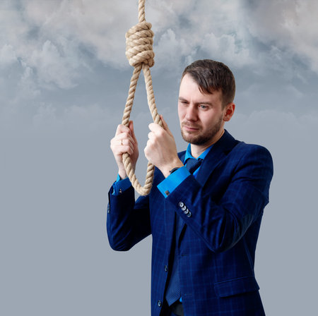 Depressed businessman wearing rope loop committing suicide.
