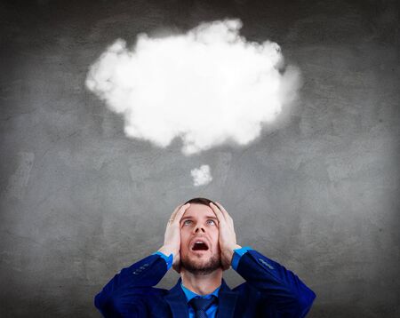 Businessman grabs the head and imagine white cloud for minds.の写真素材