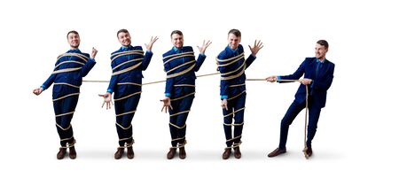 Angry businessman pulls tied himself with a rope.の写真素材
