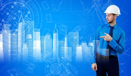 Man in hardhat and construction sketches at blue background.の写真素材