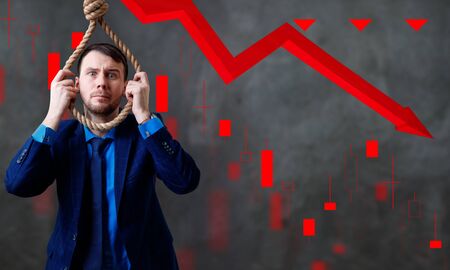 Businessman with rope on neck over gray background with red arrow.の写真素材