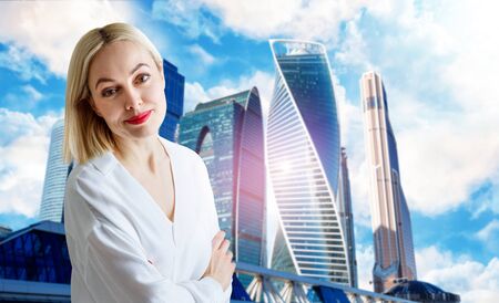 Business woman stands over cityscape background.の写真素材