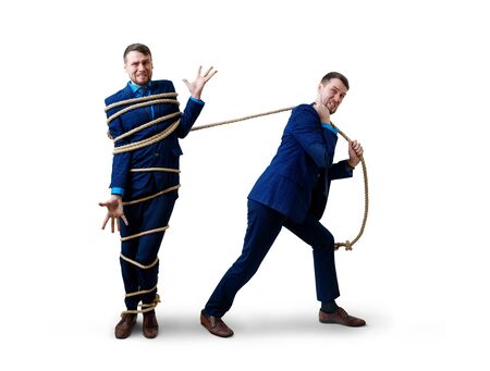 Angry businessman pulls tied himself with a rope.の写真素材