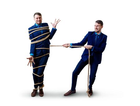 Angry businessman pulls tied himself with a rope.の写真素材