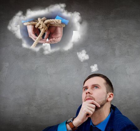 Businessman looks on tide up himself in white cloud over head.の写真素材