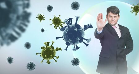 Young businessman shows stop sign among coronavirus cells.の写真素材