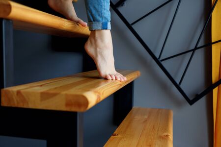 View on female legs in blue jeans go down in stairs.の写真素材
