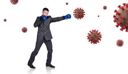 Businessman in boxing gloves punch the coronavirus cells.の写真素材