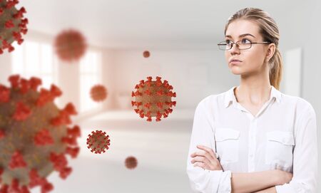 Young businesswoman among coronavirus cells in the office.の写真素材