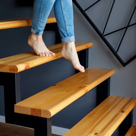 Woman in blue jeans go down in stairs.の写真素材