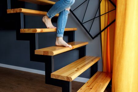 Woman in blue jeans go down in stairs.の写真素材