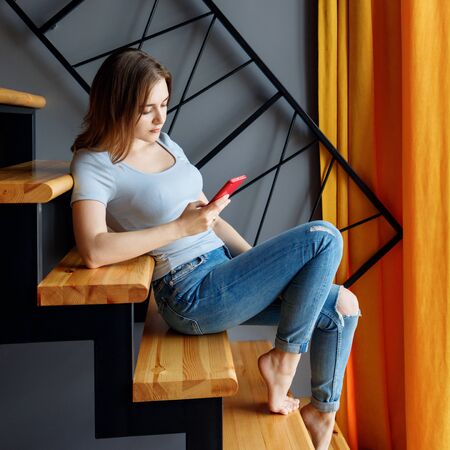 Young woman holds smartphone and surfing in internet.の写真素材