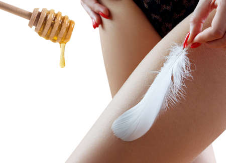 Perfect female hips near honey spoon over white background.の写真素材