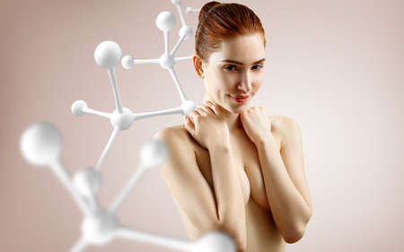 Young woman covering her breasts among molecules chain.の写真素材