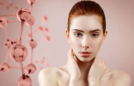 Beautiful redhead woman near pink glass molecule structure.の写真素材