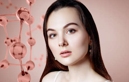 Beautiful young woman near big glass molecule structure.の写真素材