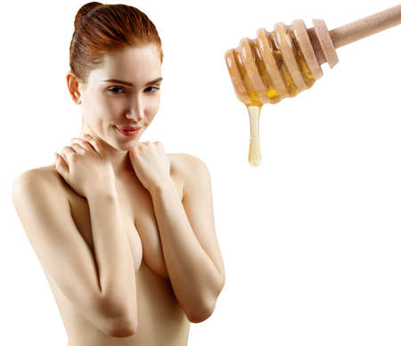 Young woman cover breast by hand near honney spoon.の写真素材