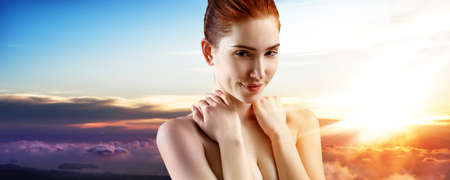 Young ginger woman over sunset.の写真素材