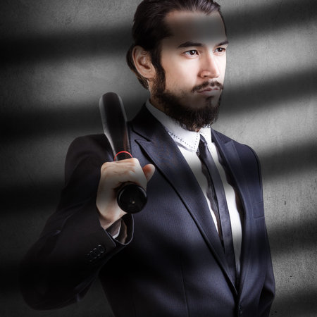 Serious man in suit with baseball bat