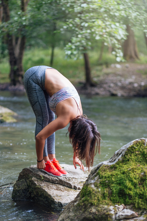 Pretty girl stretching on rocks.の写真素材