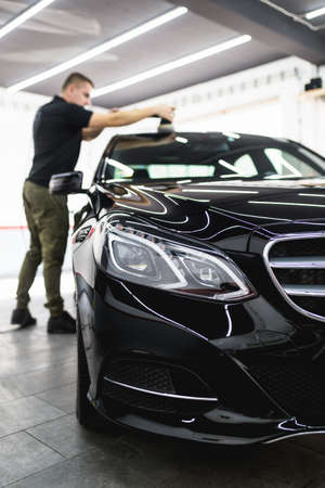 Car detailing - Worker with orbital polisher in auto repair shop.の写真素材