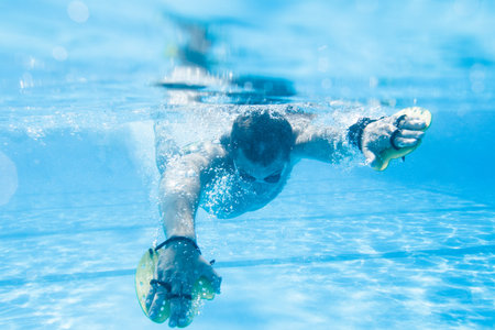 Underwater enjoyment. Young man swimming underwater and diving in the swimming pool.