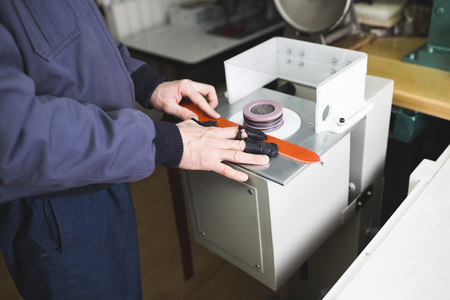 Close up shot of worker's hands in leather belt making process.の写真素材