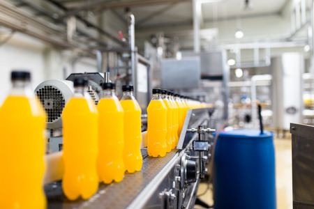Bottling factory - Orange juice bottling line for processing and bottling juice into bottles. Selective focus.の写真素材
