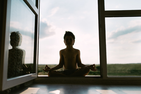 The boy meditates in the lotus positionの写真素材